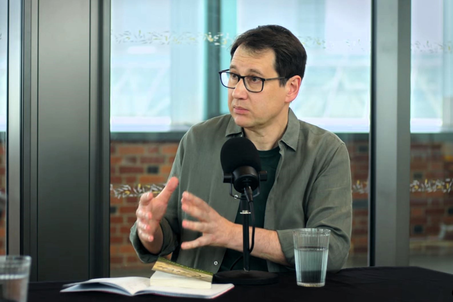 A podcast guest gestures with their hands.