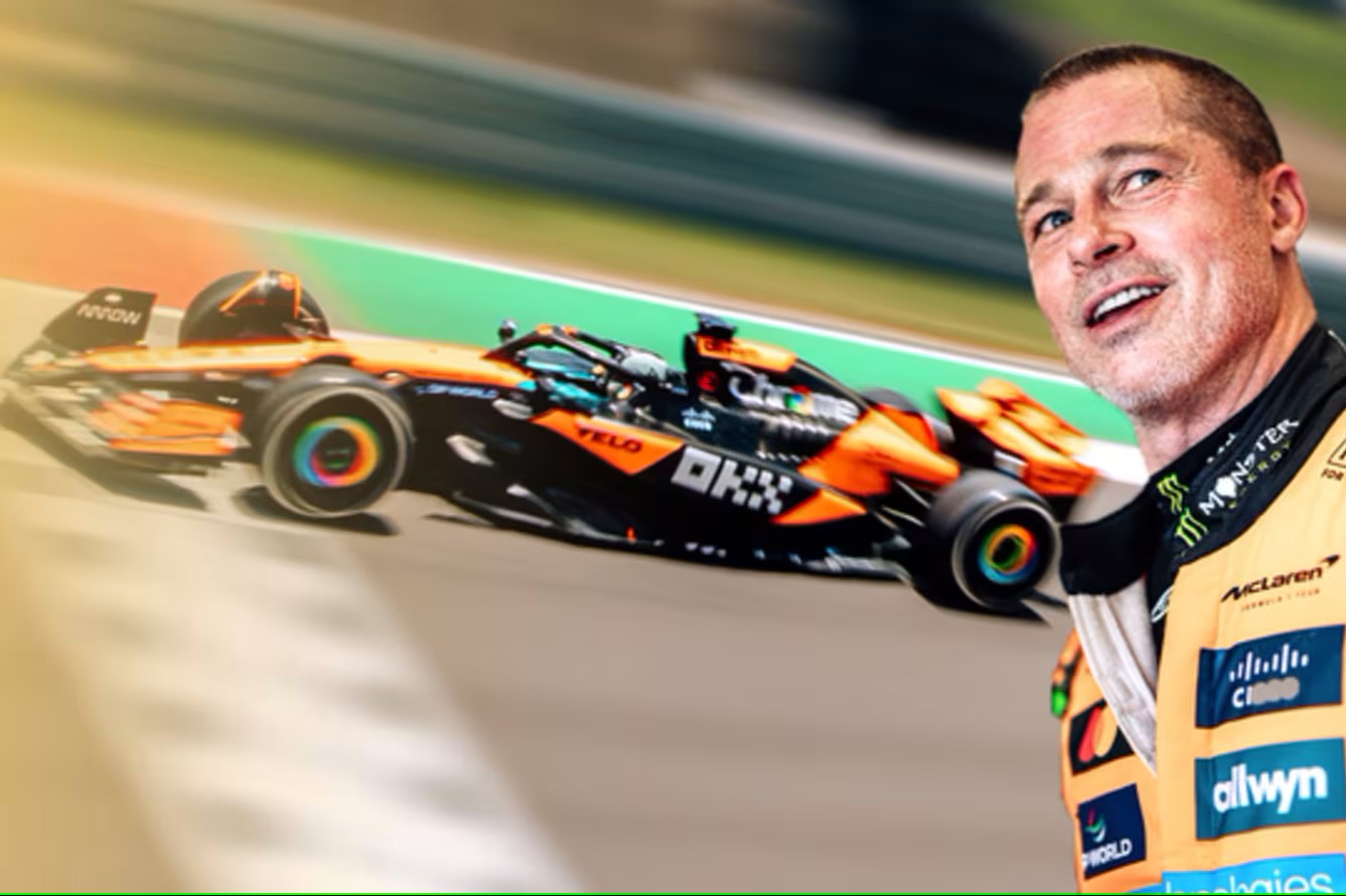 Brad Pitt dressed as a racing driver stands with a car in the background