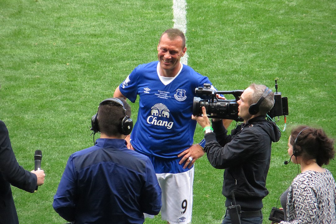 A footballer is interviewed on the side line.