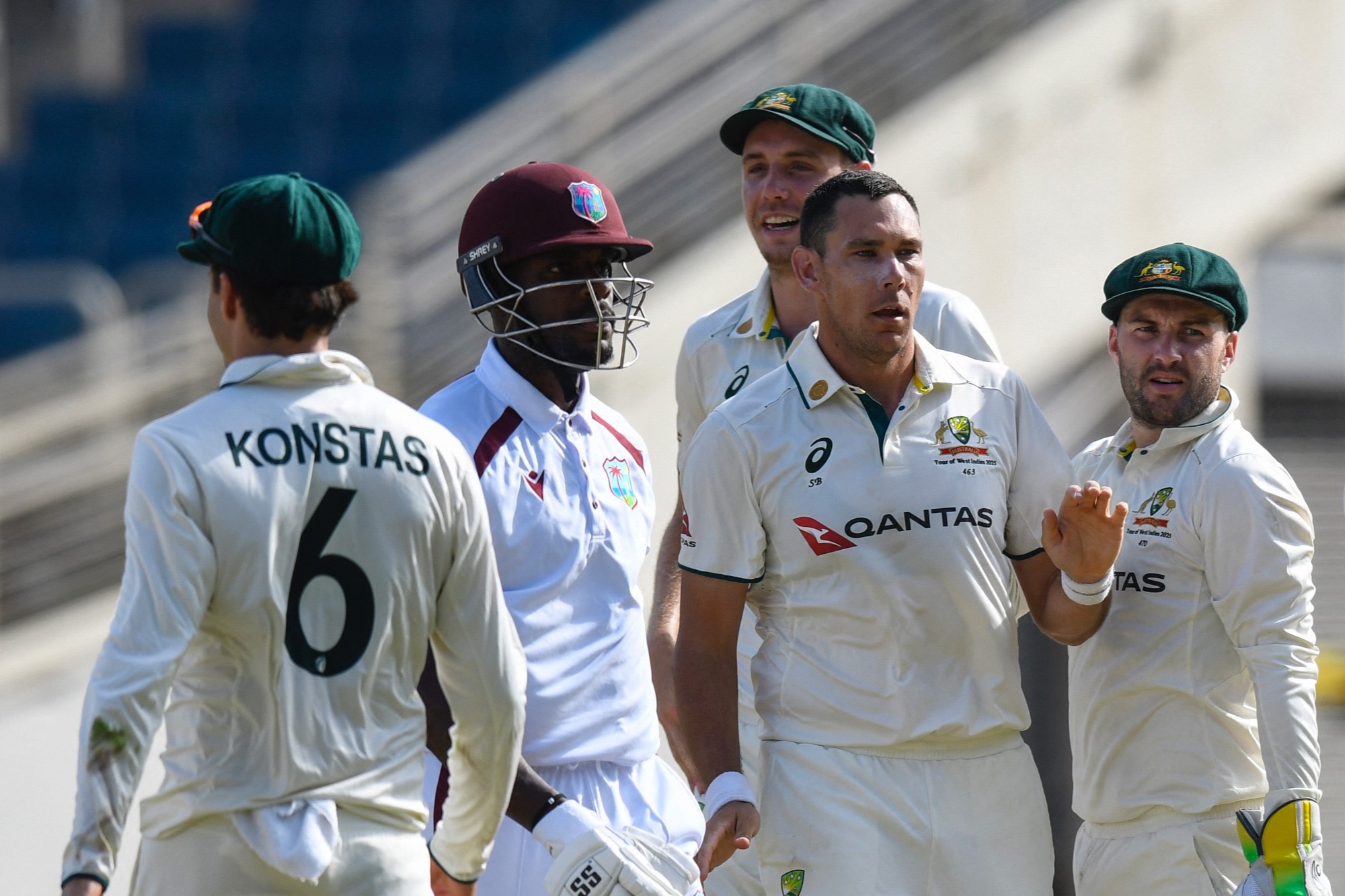 A cricket batsman surrounded by opposition players leaves the crease.