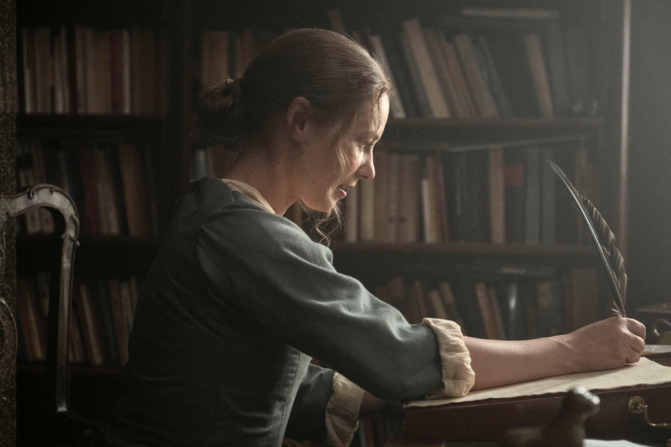 A regency woman writes with a quill
