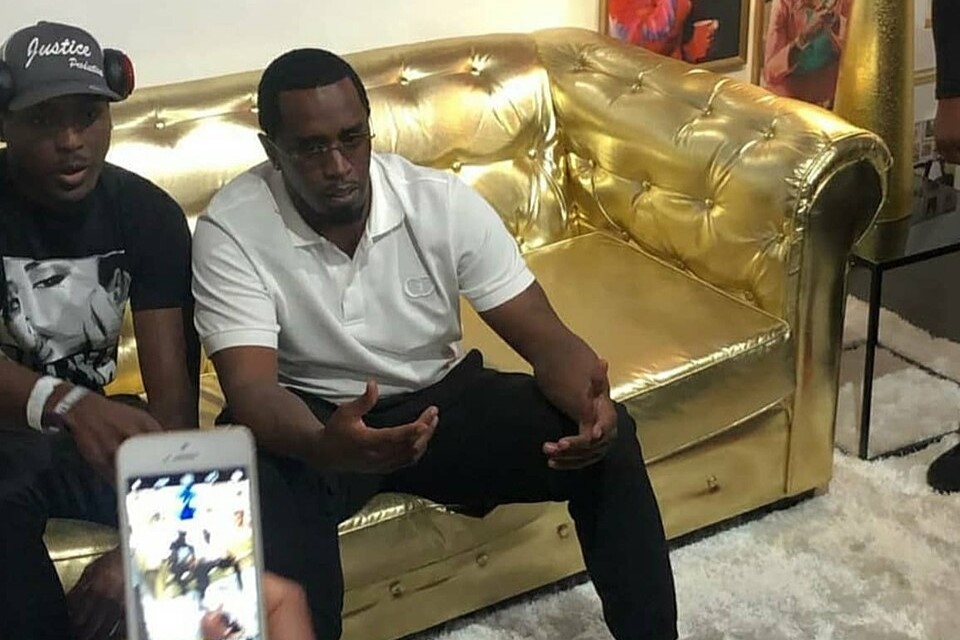 Sean Combs sits on a golden couch.