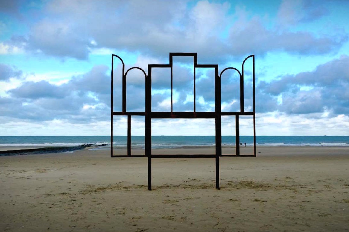 A metak sculpture outlines an altar, stands on a beach.