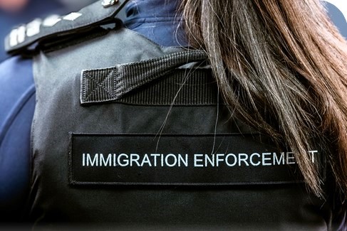 A Border Force officer wears body armour with Immigration Enforcement written on the back
