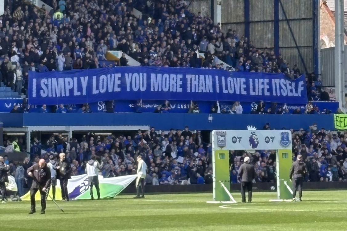 A football stand displays a long banner with text on it.