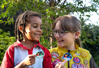Two Brownies point out their badges.