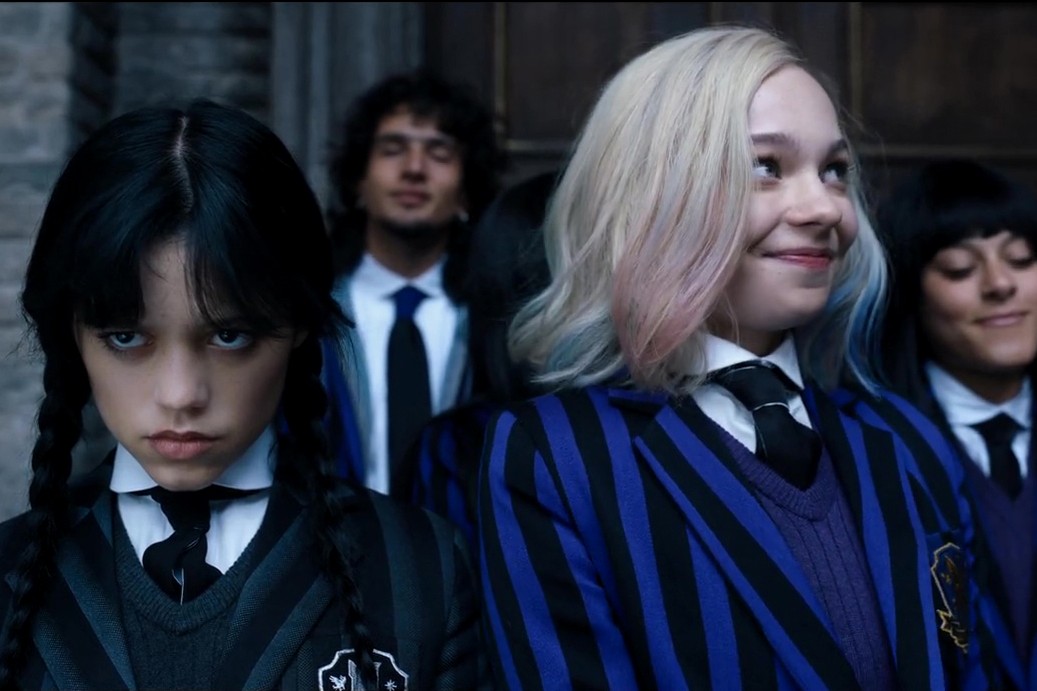 Wednesday Adams scowls while Enid smiles.