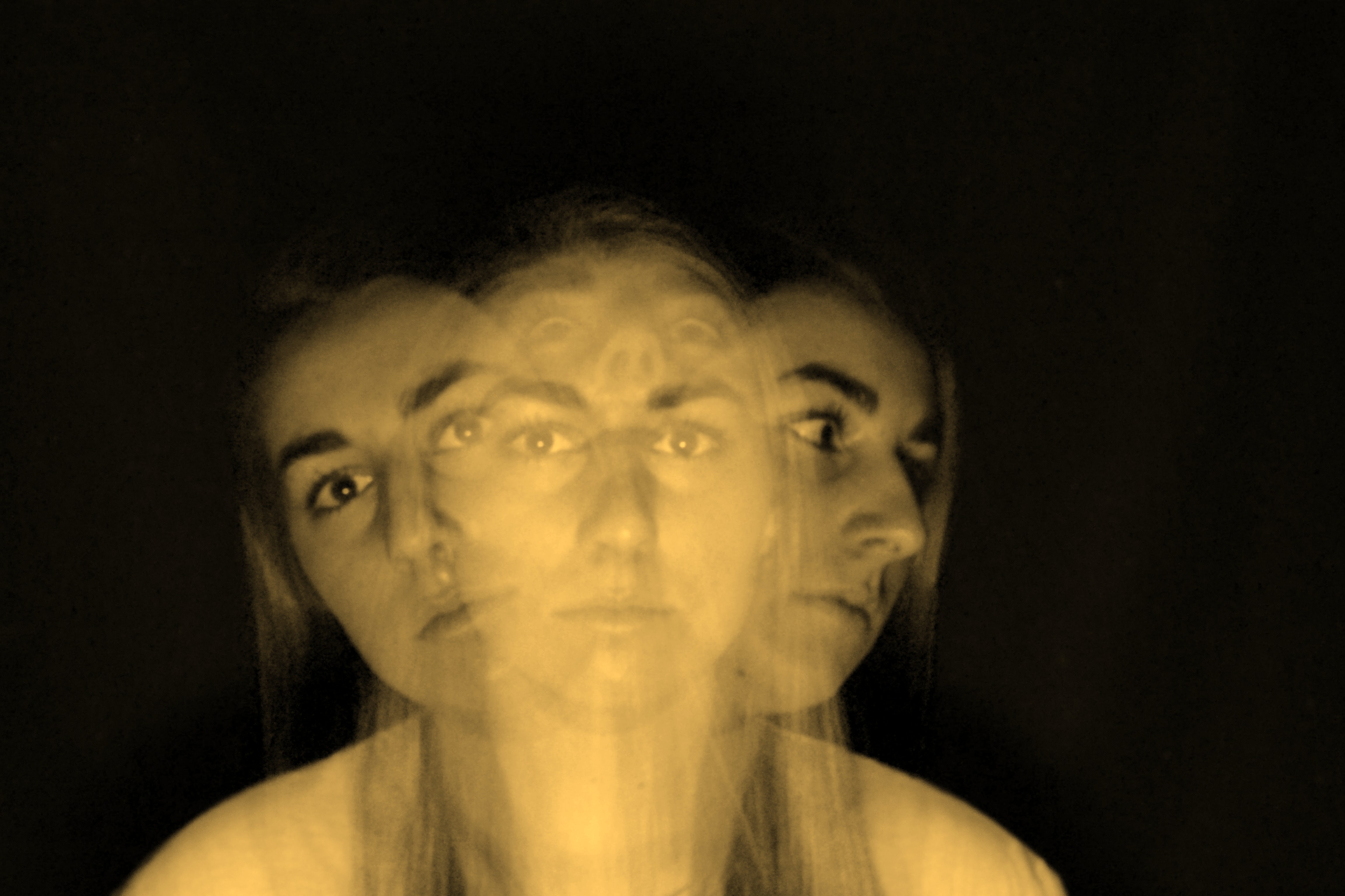 A multiple exposure image shows a womans head and shoulders looking ahead, to the sides and above.