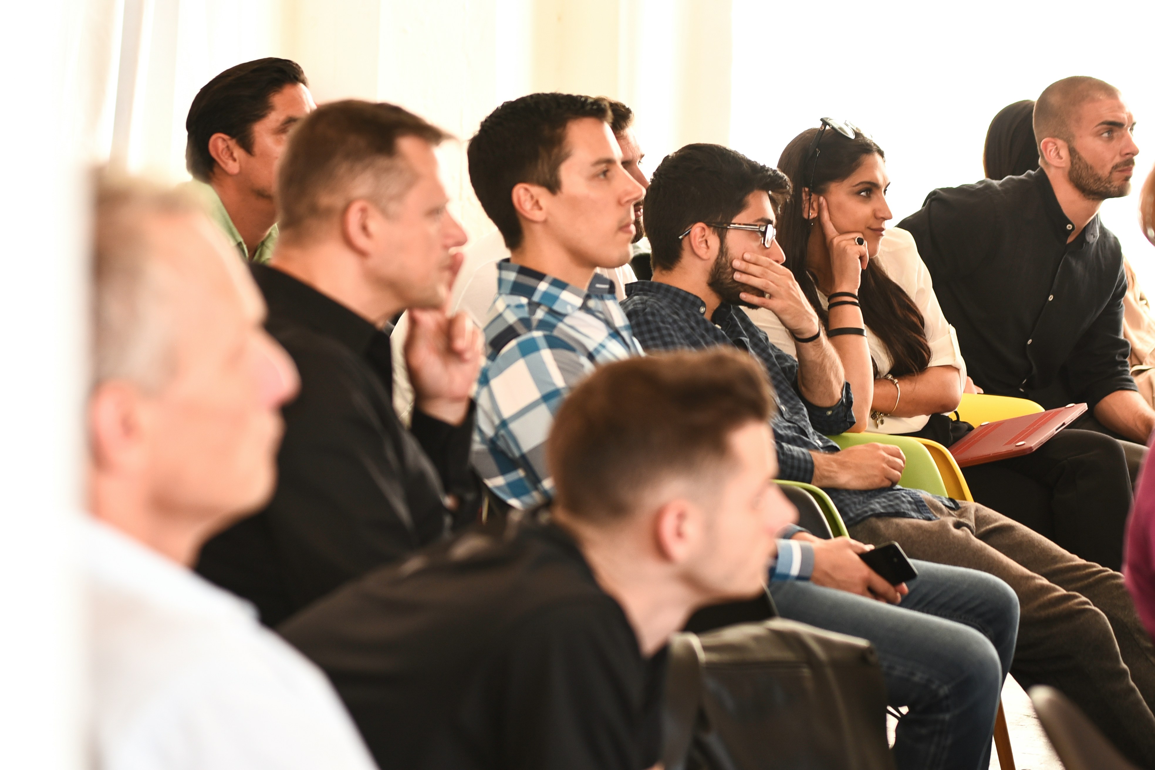 young people listen, and ponder, to a speaker off screen.