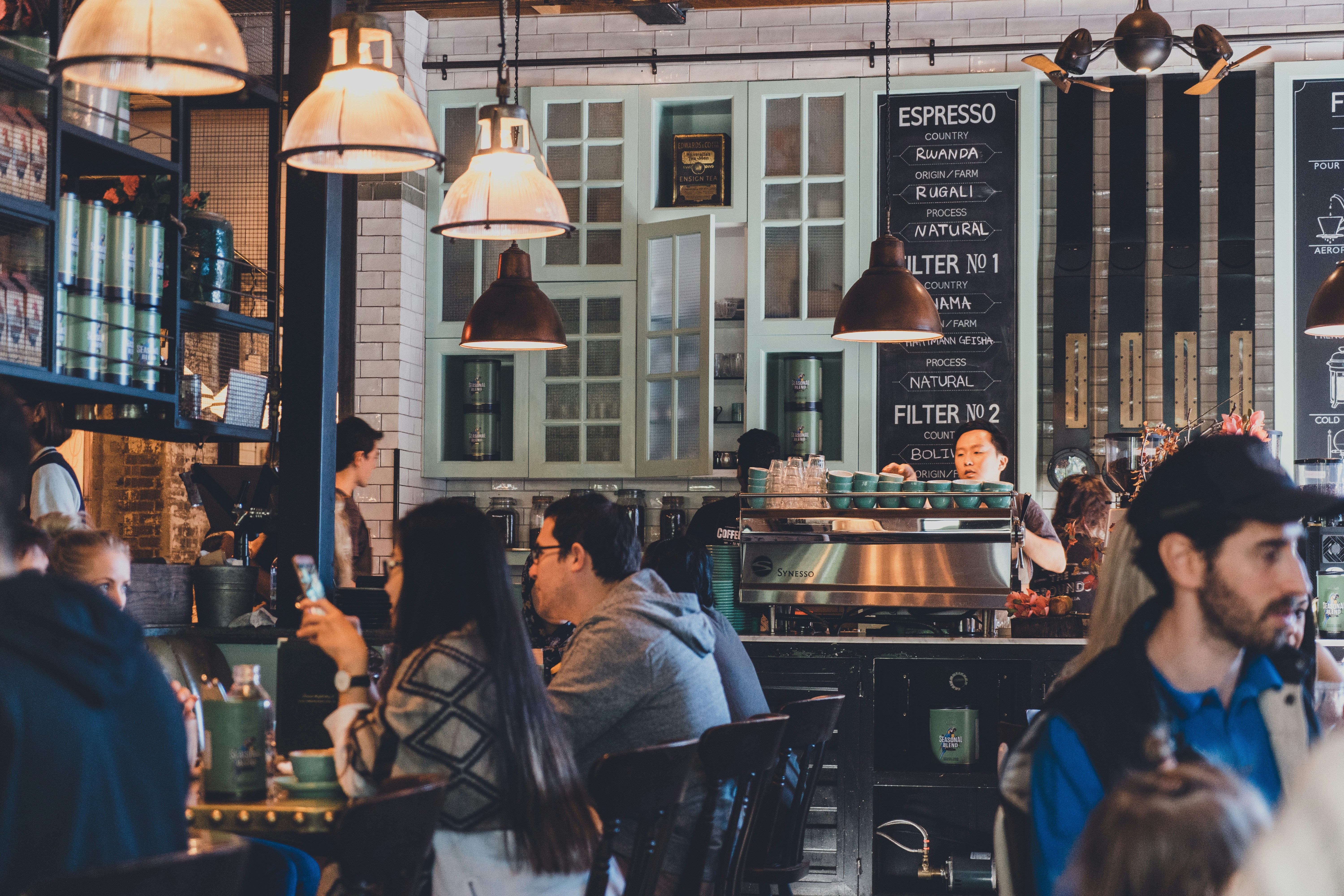 People sit in a busy cafe.