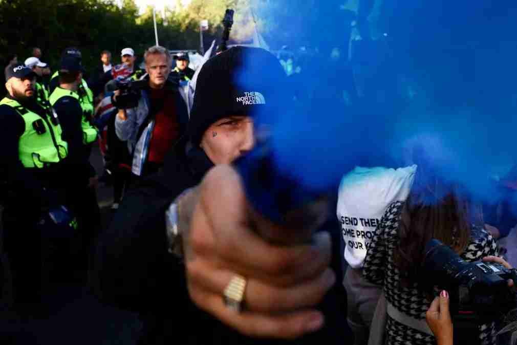 A protester hold a blue flare towards the camera