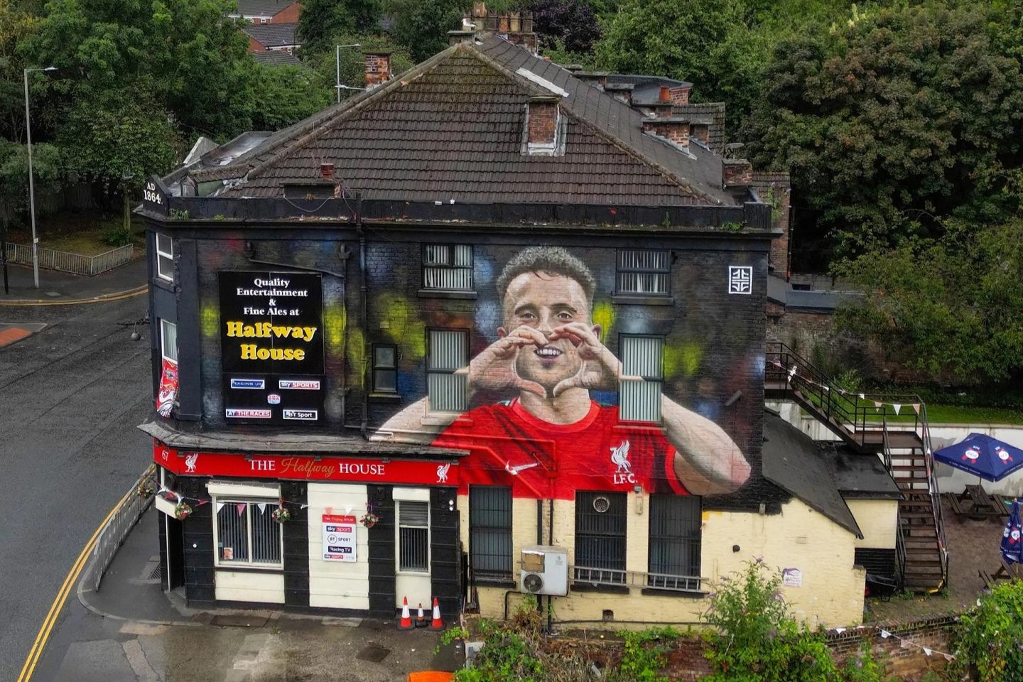 An aerial view of a pub with a large mural of a footballer on it