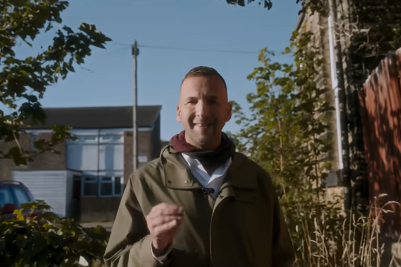 Zack Polanski walks down an alleyway
