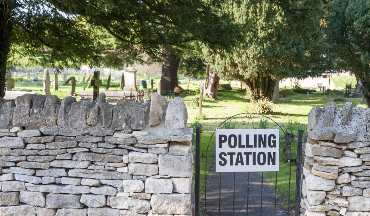 A gate to a churchyard displays a sign saying polling station.