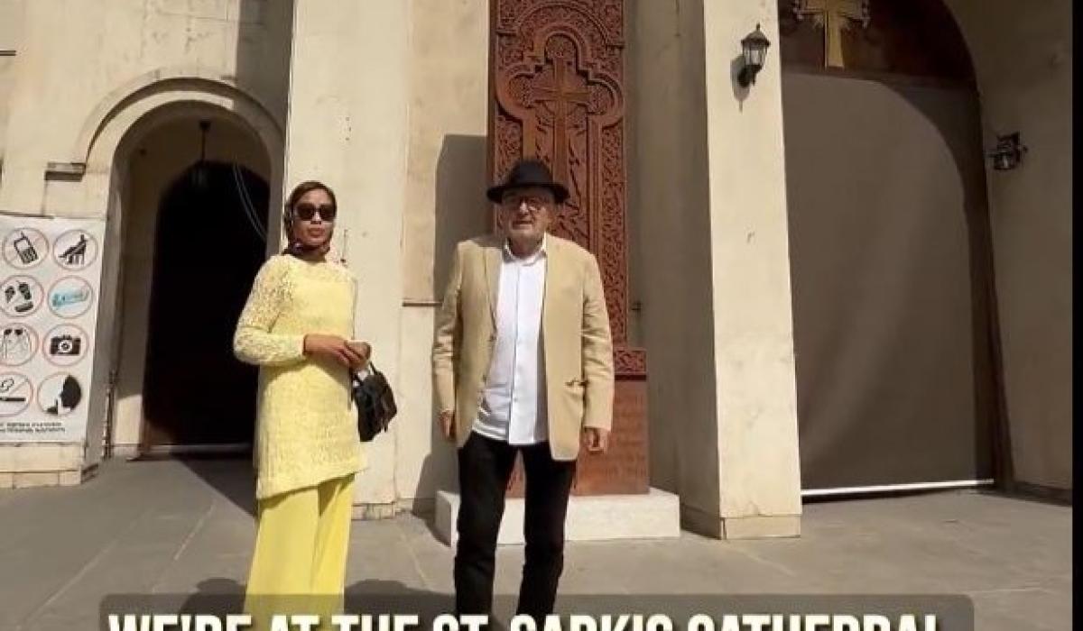 A couple stand on the steps of a cathedral in Iran.