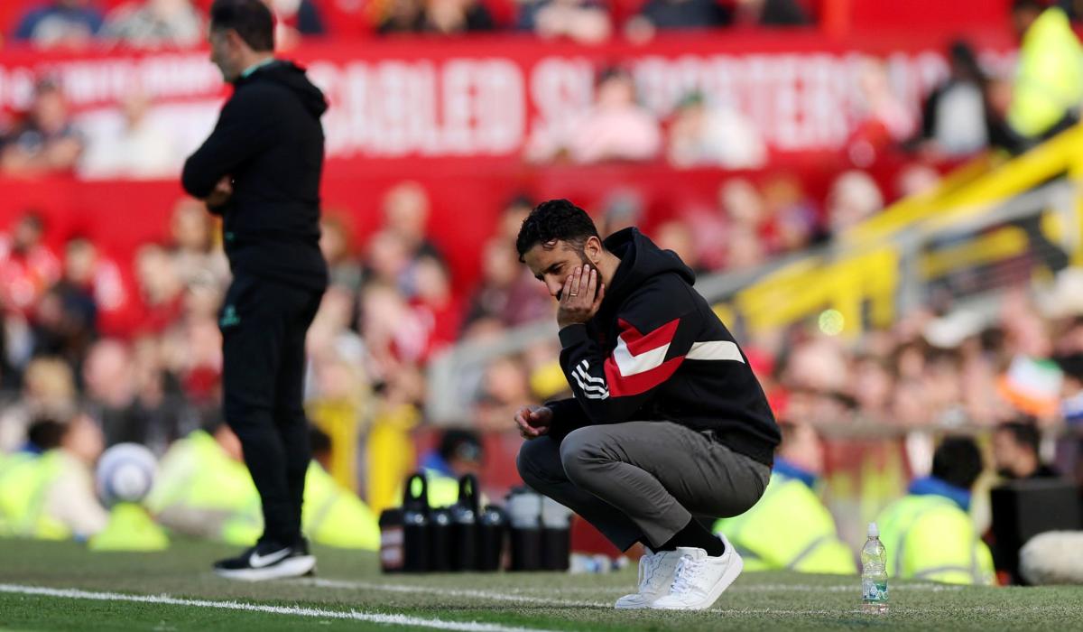 A dejected football coach squats by the byline.