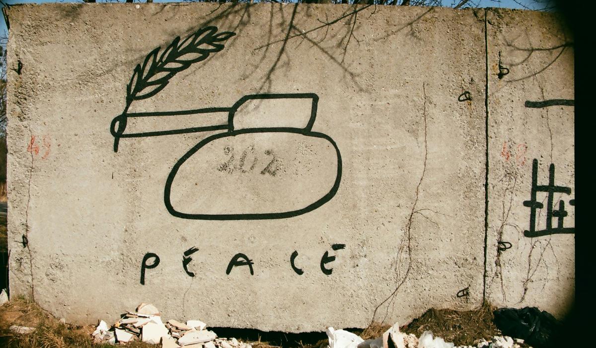 Graffiti of a tank with a peace laurel coming out of its barrel.