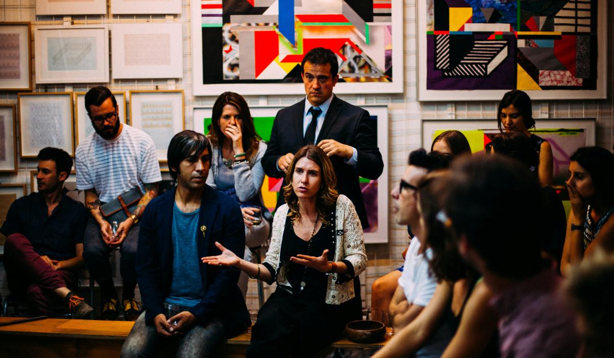 A member of an audience makes a point while gesturing.