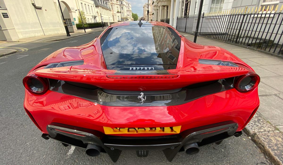 A red Ferrari parked on a posh London Street