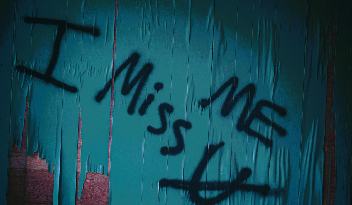 Graffiti reads 'I miss me' with u crossed out under the 'mem'