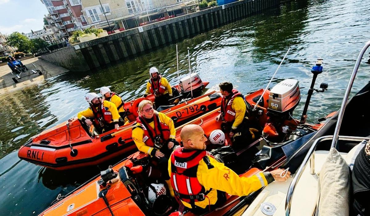Two small lifeboats raft together on a river rescue.