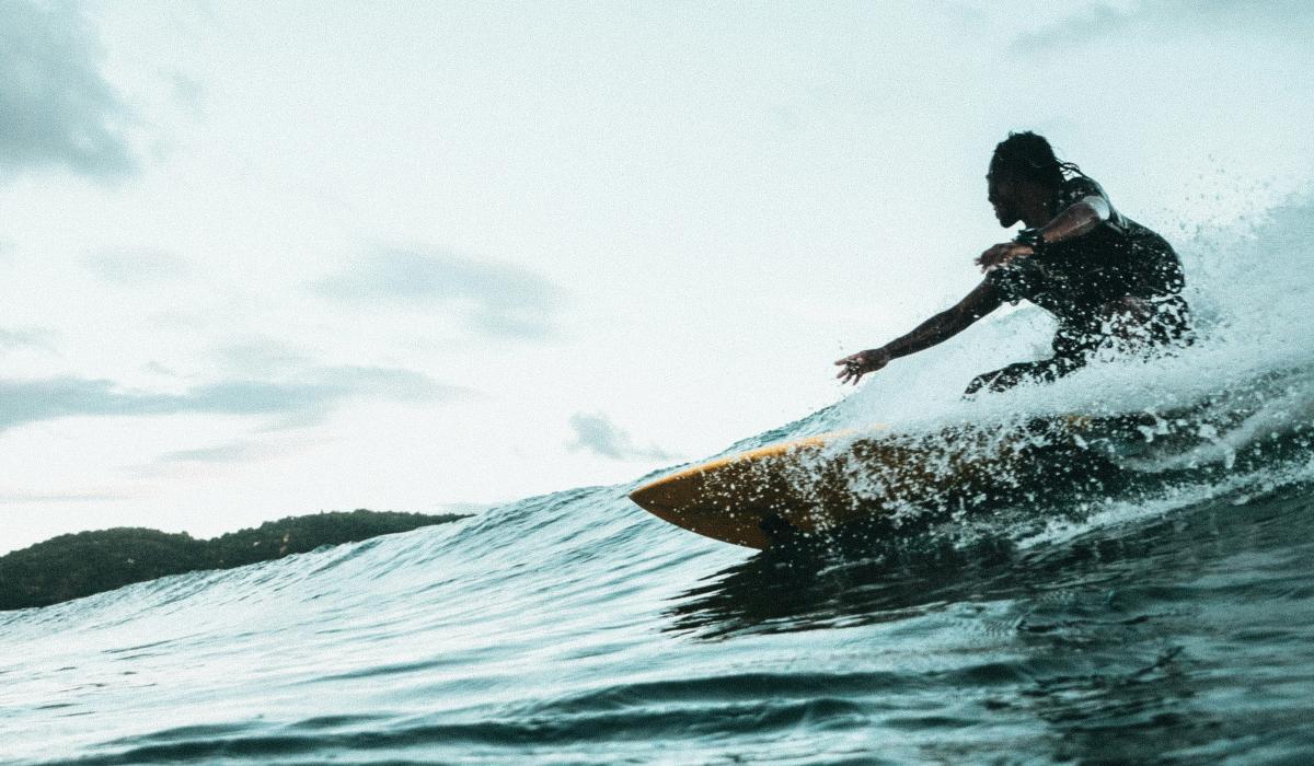 A surfer carves a turn on a wave.