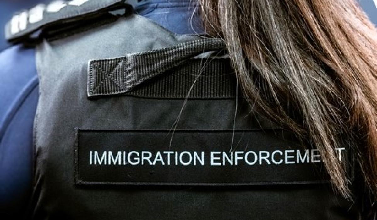 A Border Force officer wears body armour with Immigration Enforcement written on the back