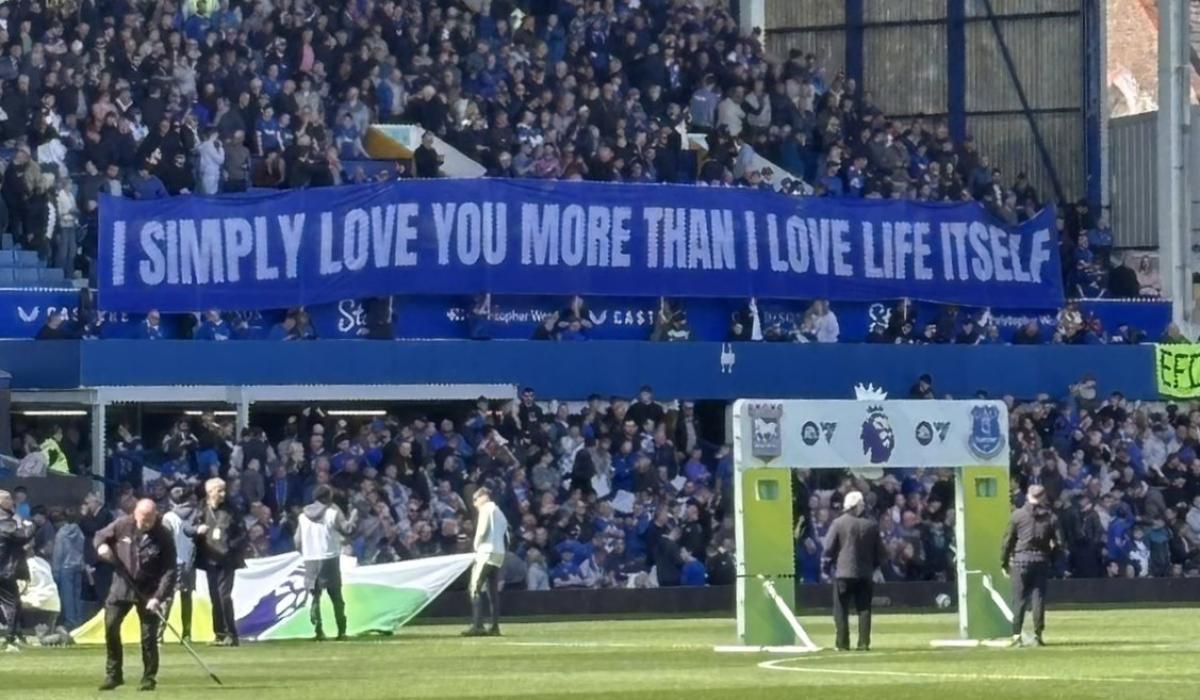 A football stand displays a long banner with text on it.