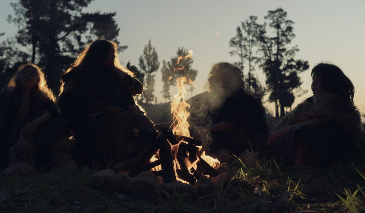 A re-enactment of an ancient 'caveman' family sitting around a camp fire.