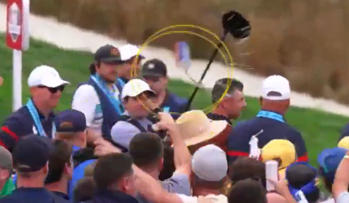 A video still shows a beer can thrown at a golf amid a crows