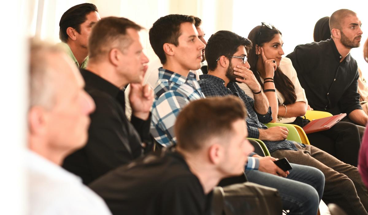 young people listen, and ponder, to a speaker off screen.