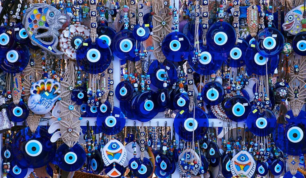 Blue evil eye charms hang among a jewellery display