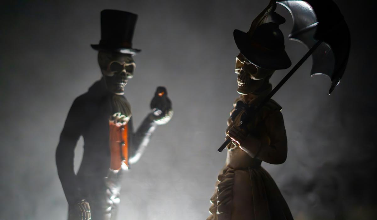 Skeleton figurines clothed in Victoria outfits.