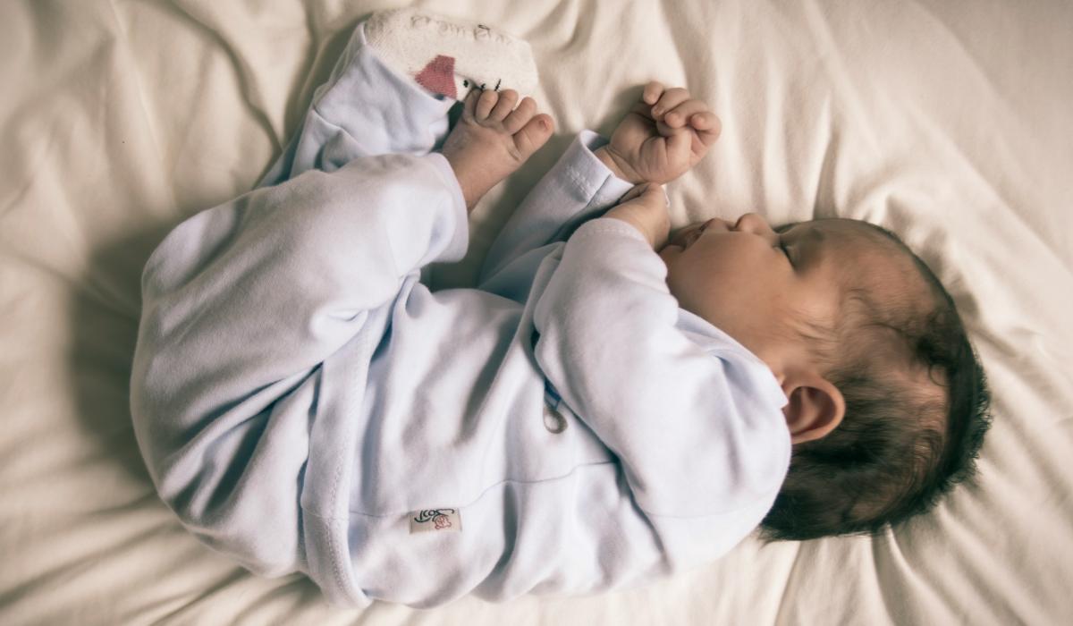 A baby sleeps curled up.