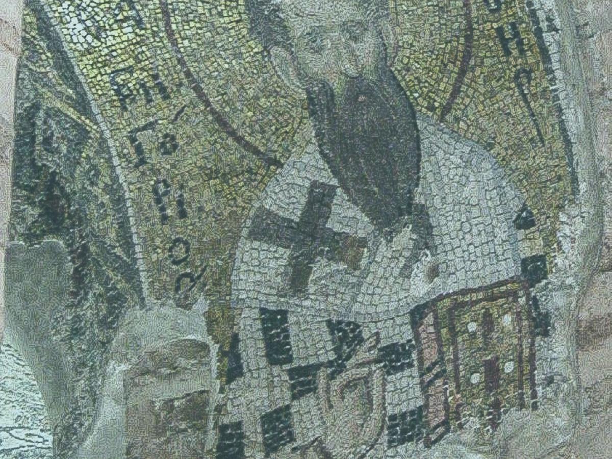 A mosaic shows a saint with a beard holding a bible and his hand held up in a blessing.