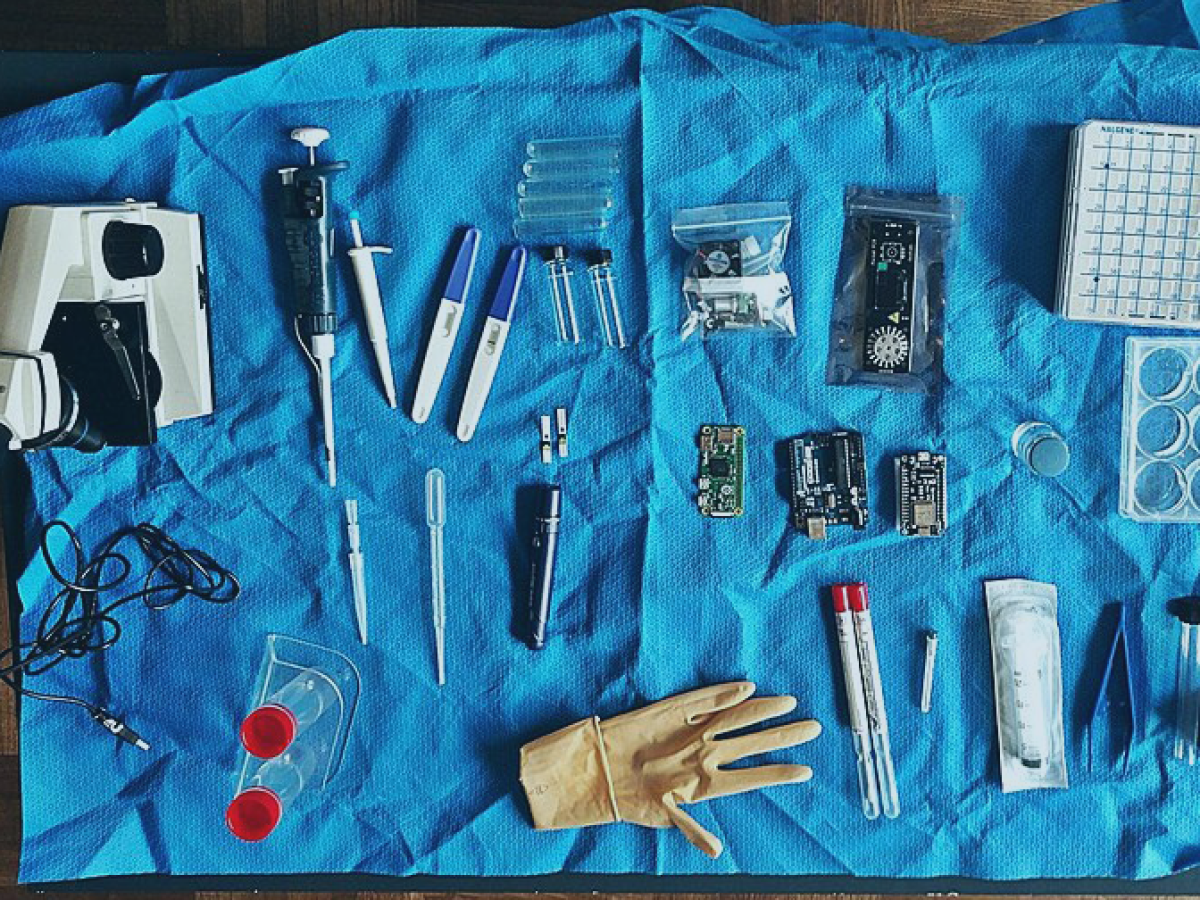 A plastic sheet strewn with biology-related instruments.