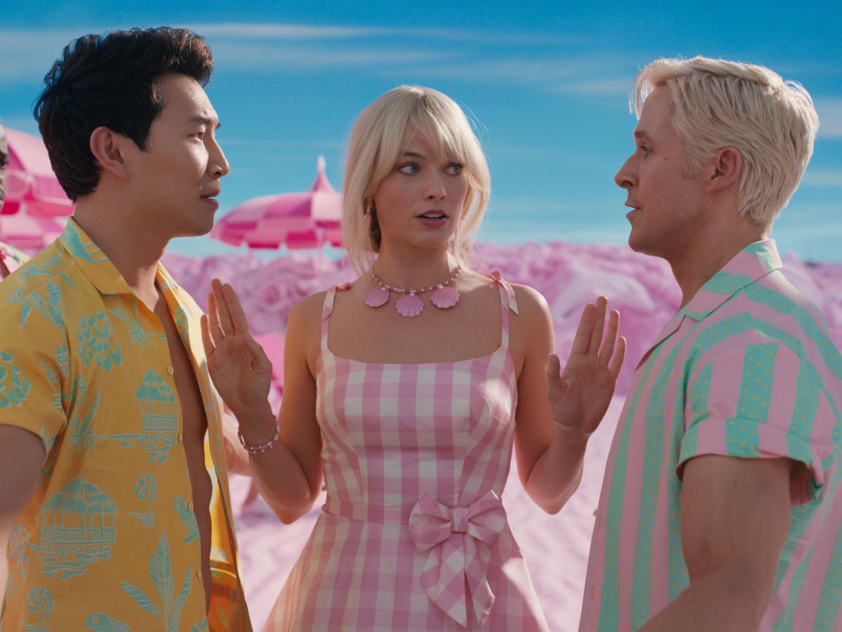 Barbie stands between Ken and a rival with her hands raised.