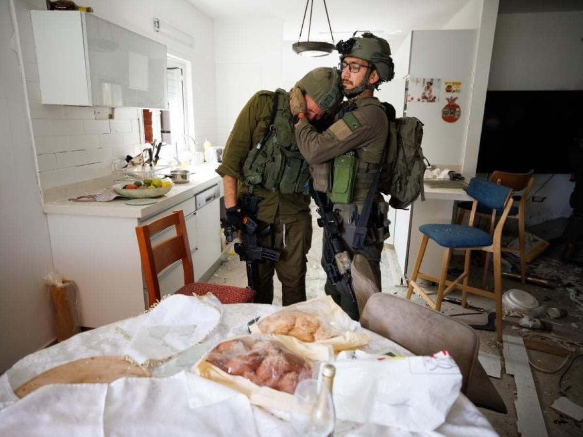 Two soliders console each other as they search a house that has been ransacked.