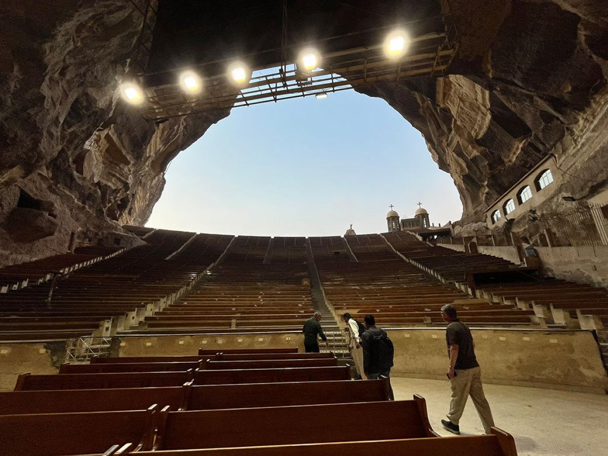 a view from the bottom of a huge cave to the sky, up row upon row of seating tiers.