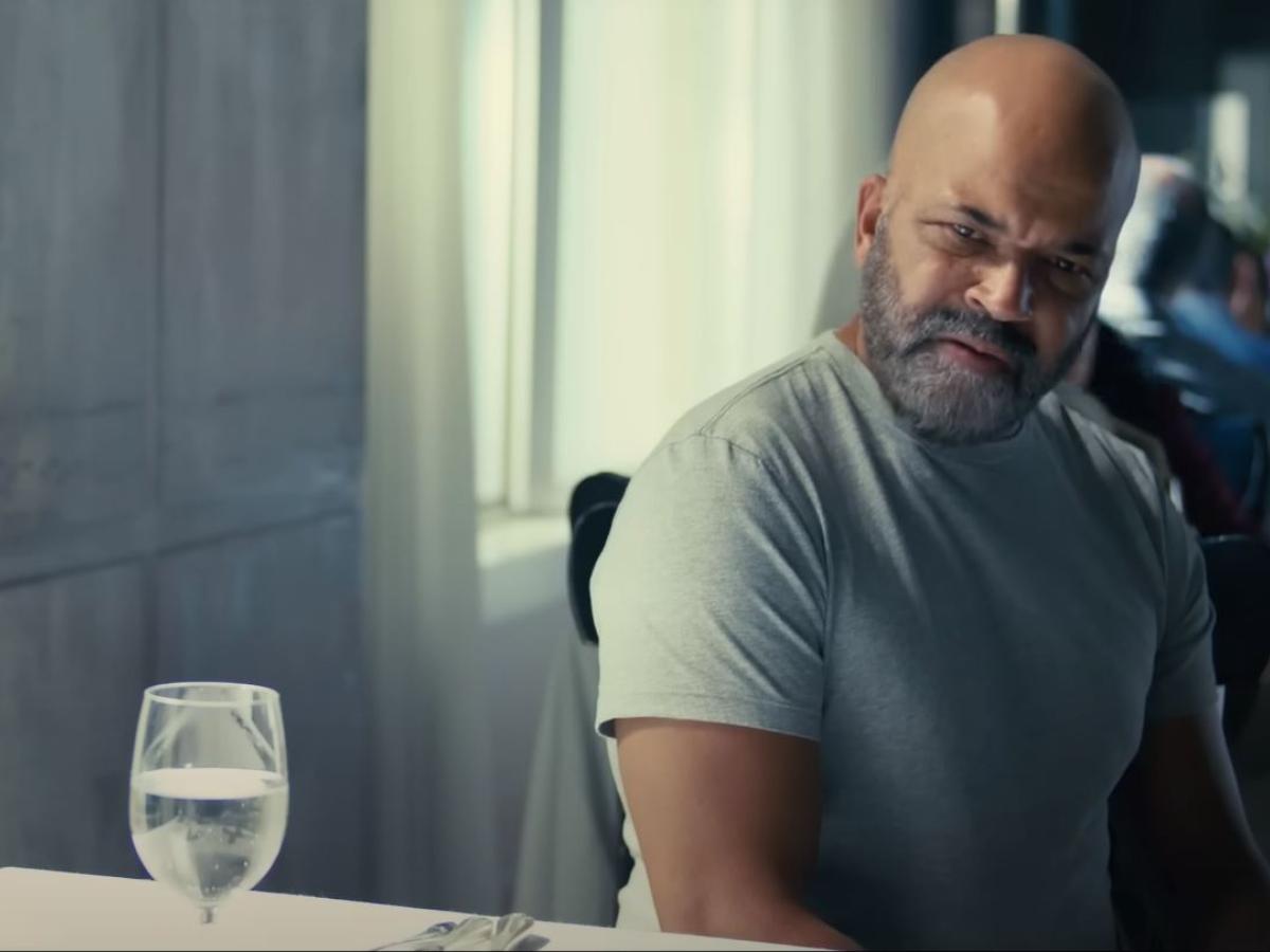 A man sitting at a restaurant table turns and looks aside.