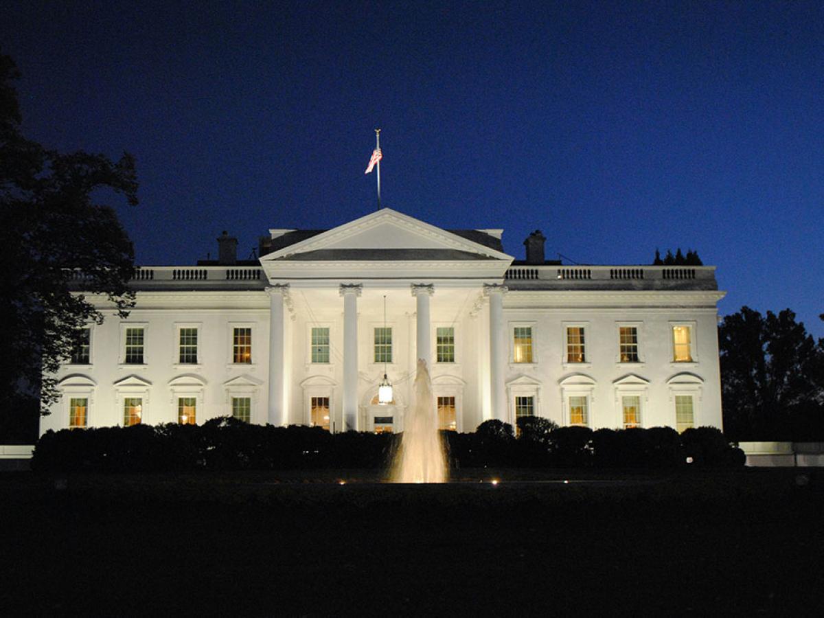 The White House illuminated against the night sky.