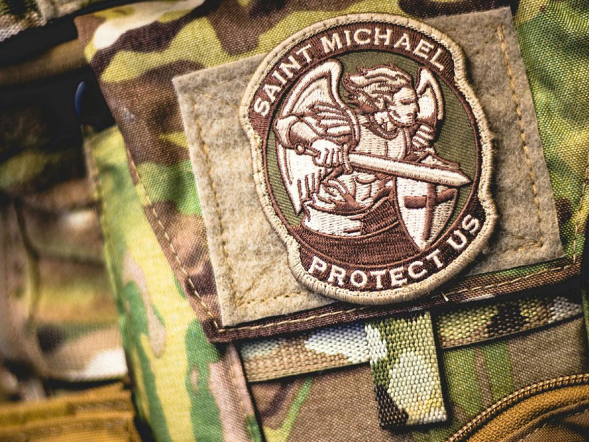 A patch depicting a angel in armour, wielding a sword, on camoflague uniform.
