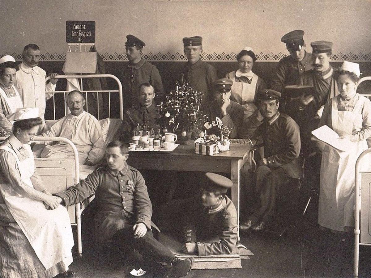 A black and white photo shows solider patients and nurses in a hospital.