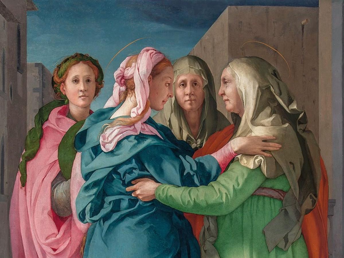 A Renaissance painting of Elizabeth greeting the Virgin birth show two woman reaching out to hug, while others look on.