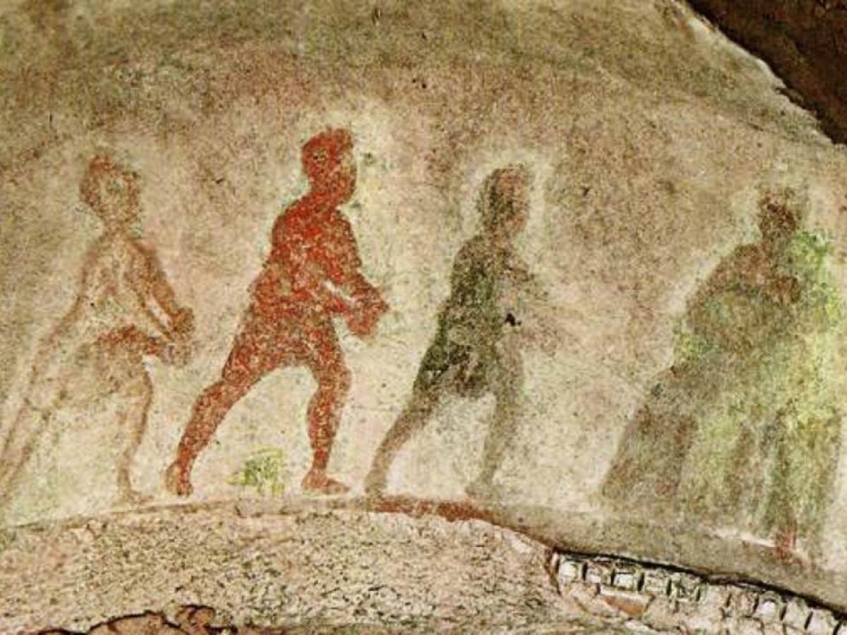 Silhouttes of three wise men approach the Virgin and Child, painted on stone. 
