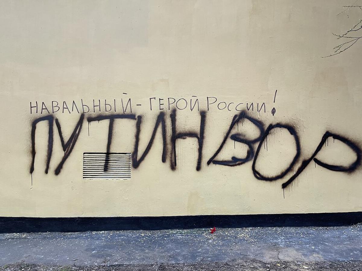 Graffiti on a wall, spells out in Russian character the name Navalny.