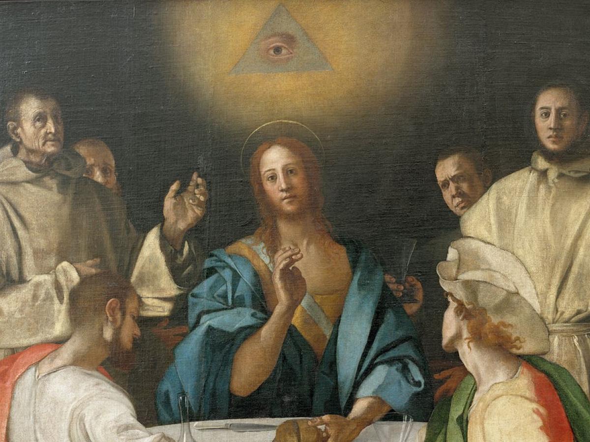 an all seeing eye hovers above a renaissance style picture of the supper at Emmaus.