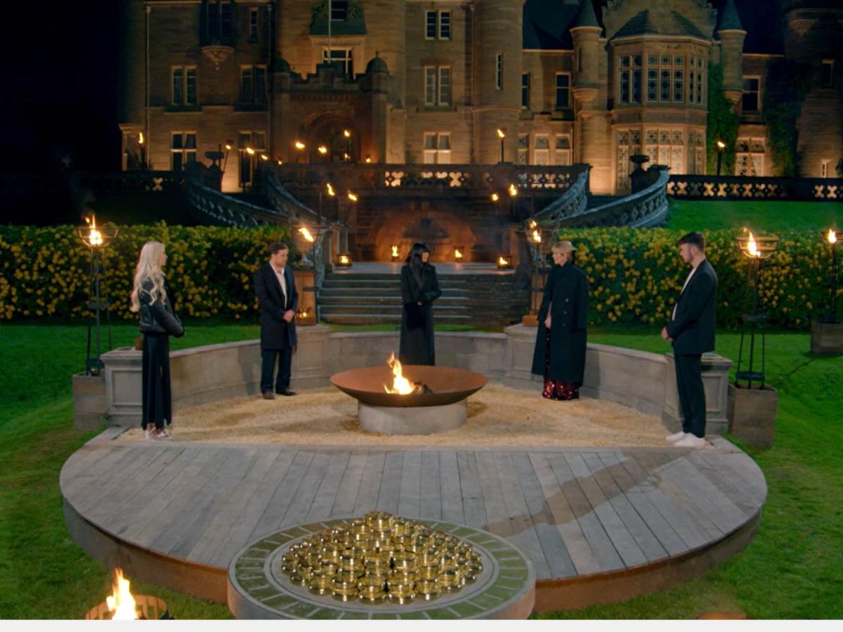 Four game show contestants and a host stand in the garden of stately home.