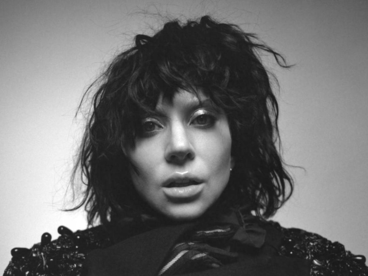 A black and white photo of a woman about to open her mouth to sing.