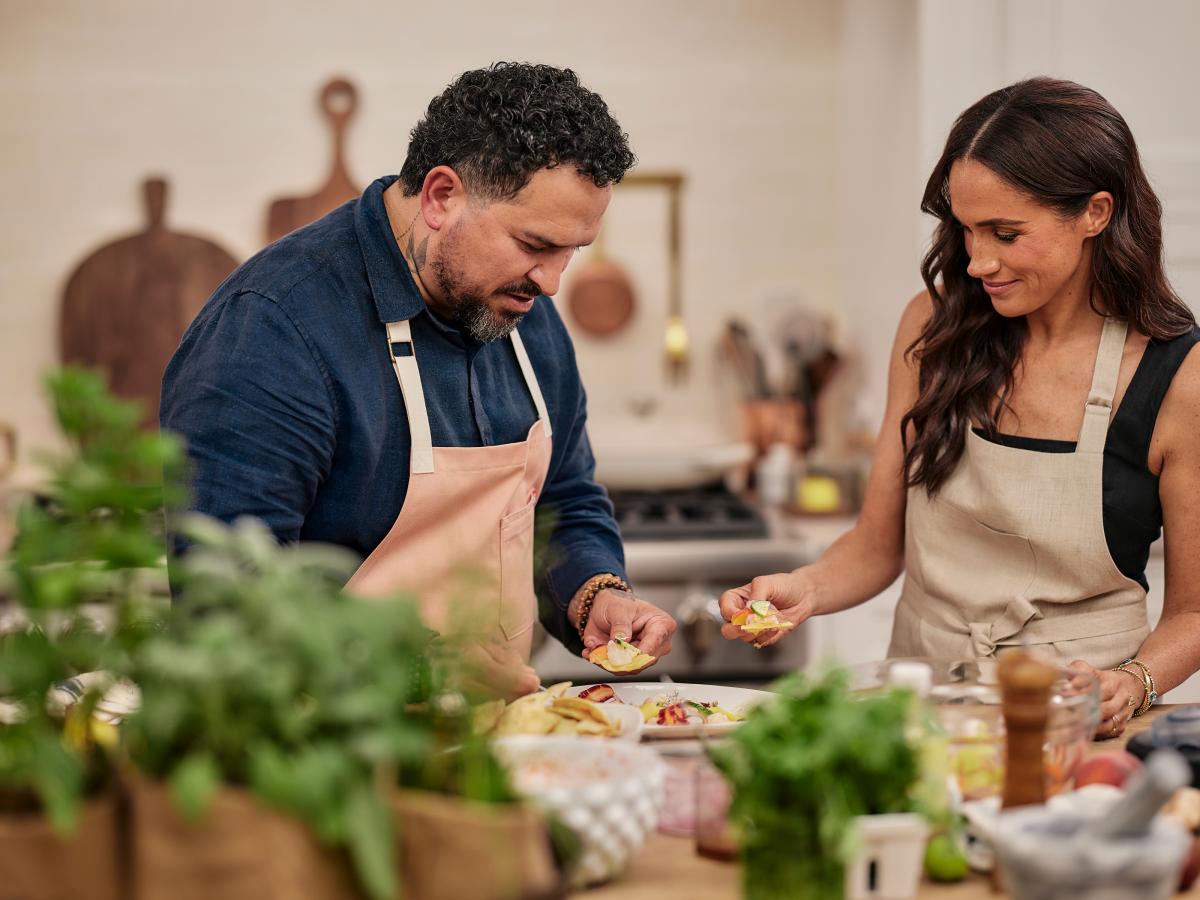A man and a woman prepre food in a kitchen.